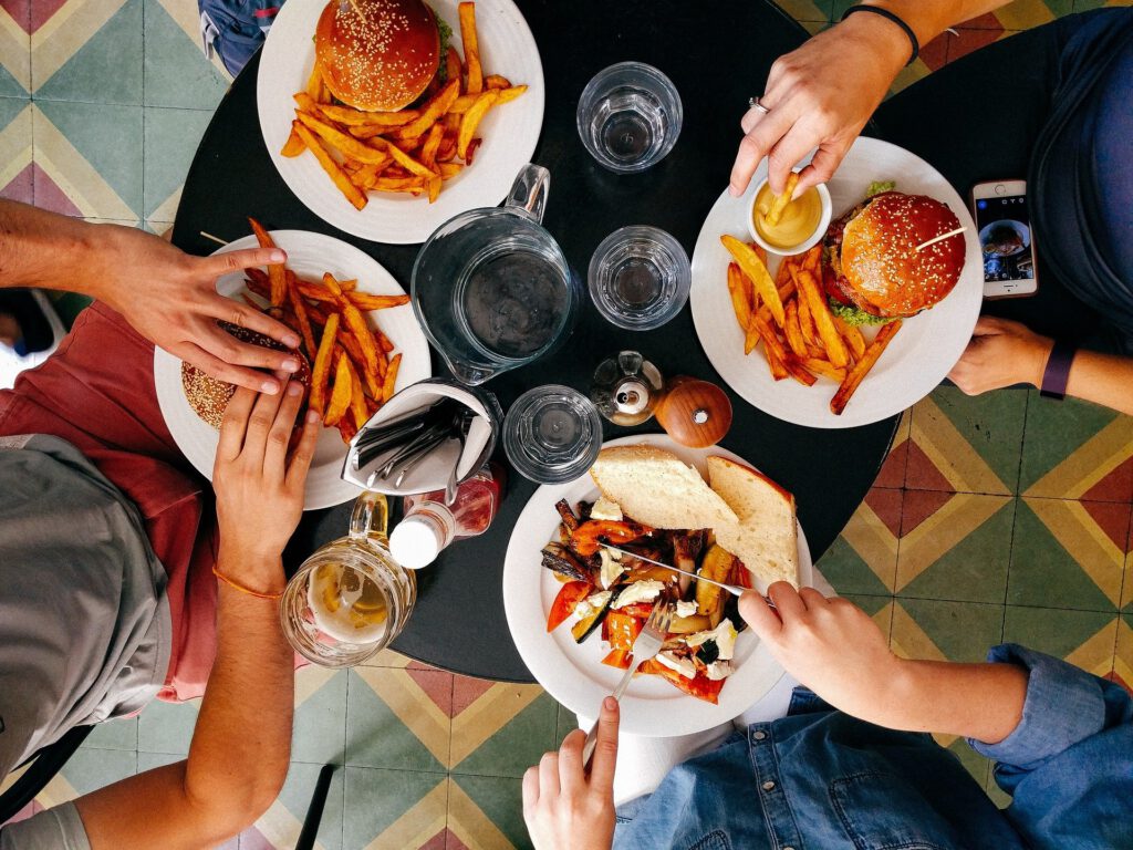 four people eating food together at a table