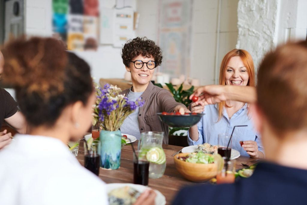 group of people eating food together at the dinner table