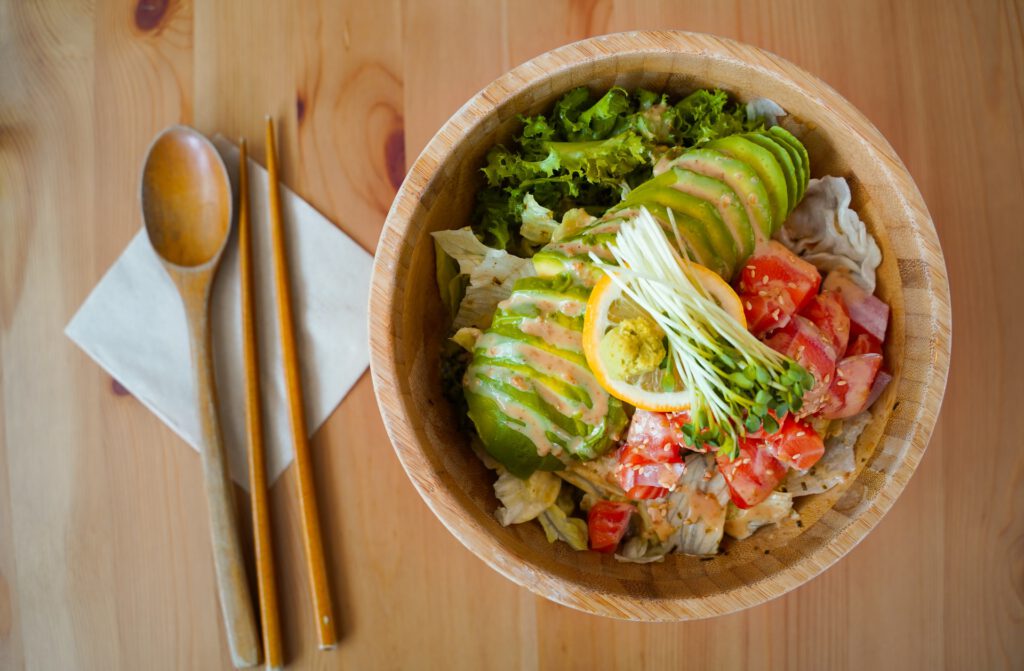 Wooden bowl with salad greens on a table