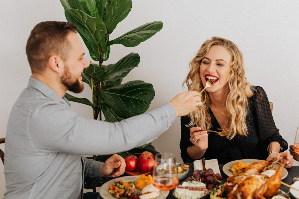 Man Feeding His Girlfriend During a Homemade Dinner 
