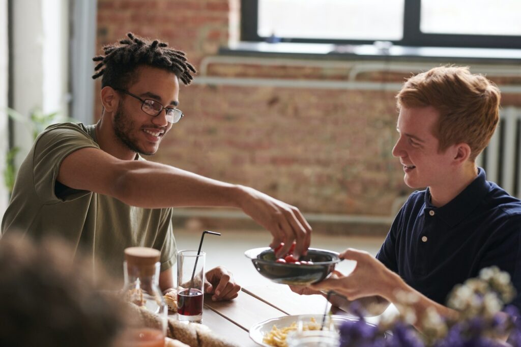 two men sharing food