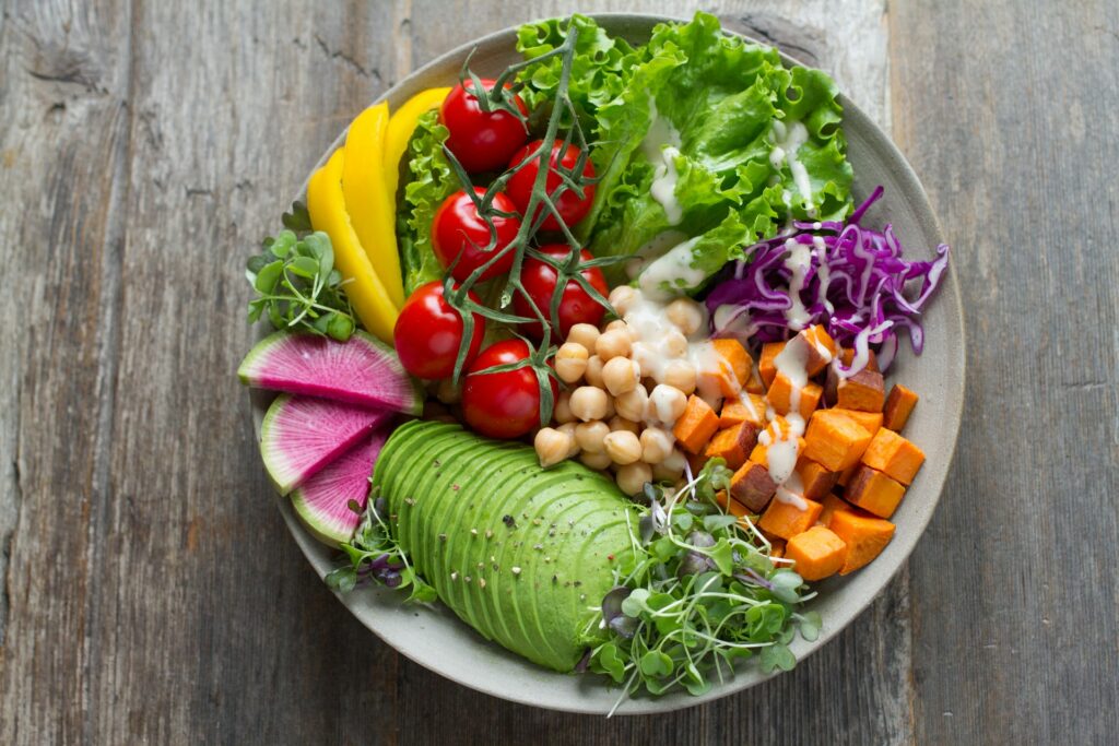 a bowl of fresh veggies on a wooden table