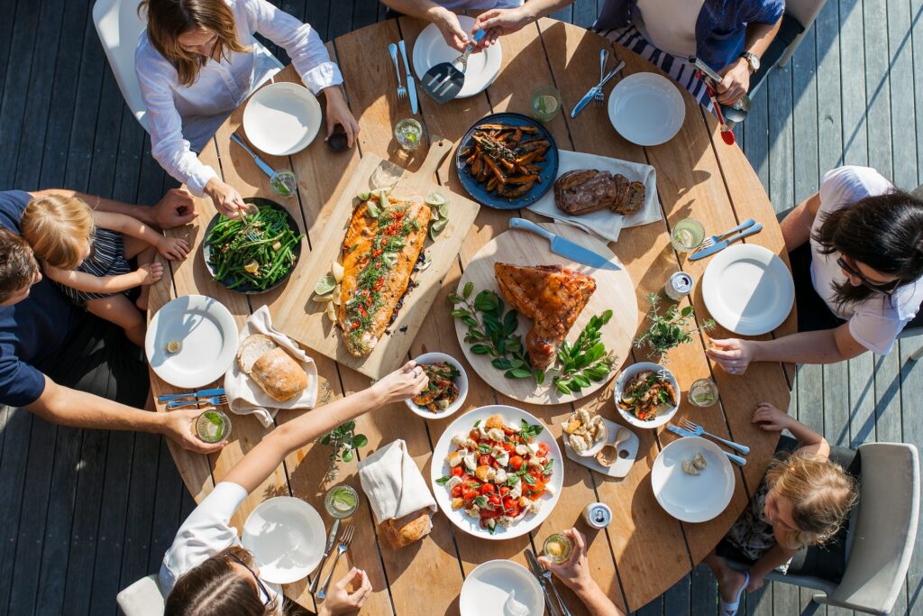 Group of people eating at a table with a big meal