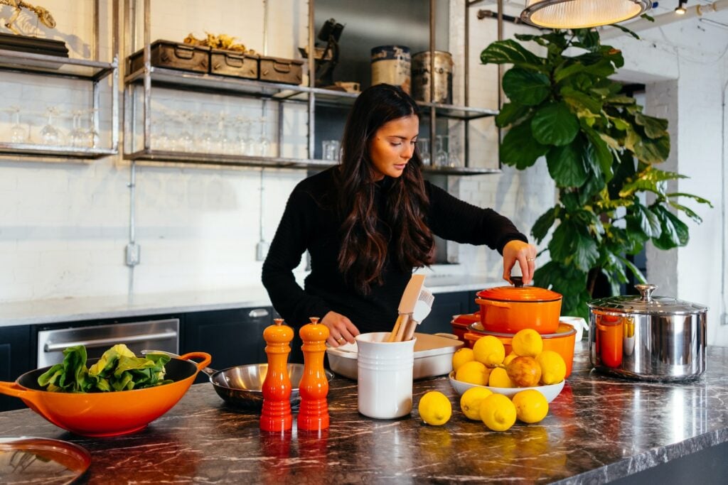 woman standing in kitchen getting ready to cook