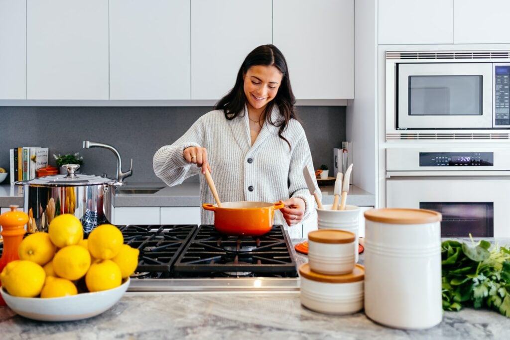 Woman mixing a sauce in a pot in the kitchen