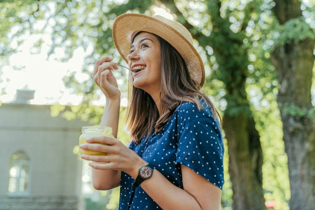 Women wearing a hat and eating with a spoon