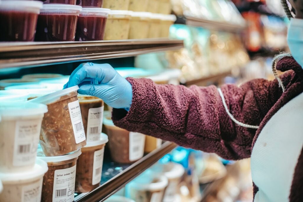 Hand reaching for a soup container with nutrition label