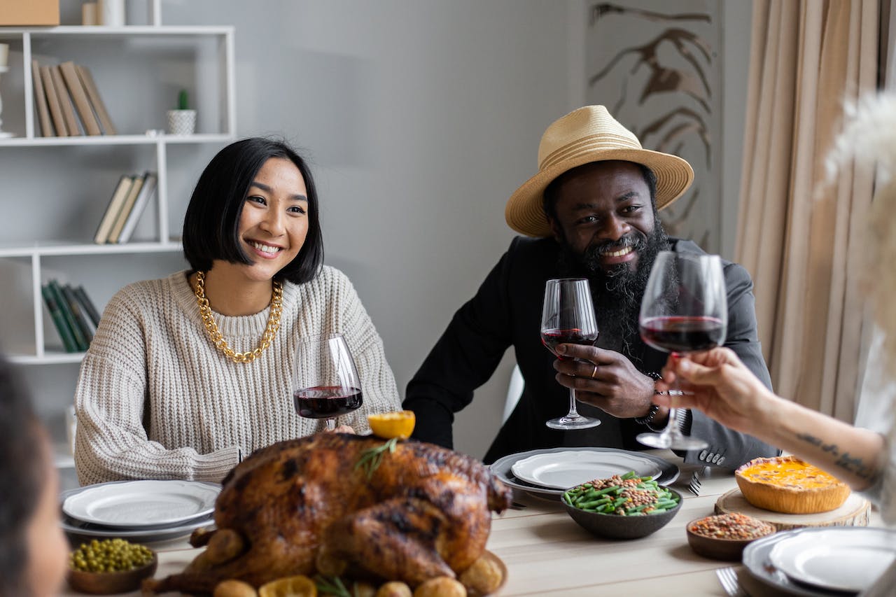 Couple drinking wine on thanksgiving with guests